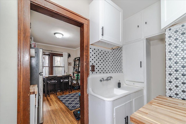 bathroom featuring crown molding, wood-type flooring, and tasteful backsplash