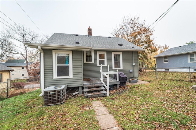 back of house with cooling unit and a yard