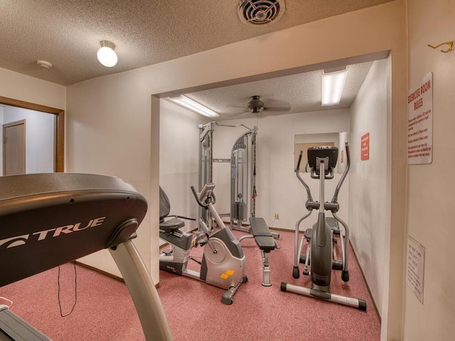 exercise area with ceiling fan and a textured ceiling