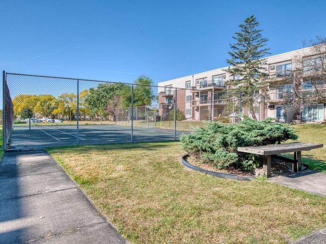 view of tennis court with a lawn