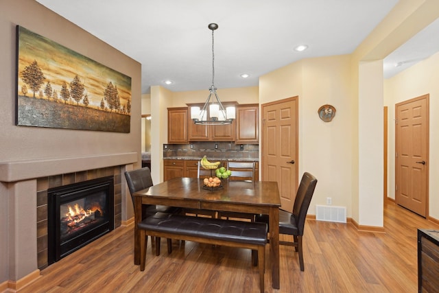 dining space featuring light wood-type flooring and a fireplace