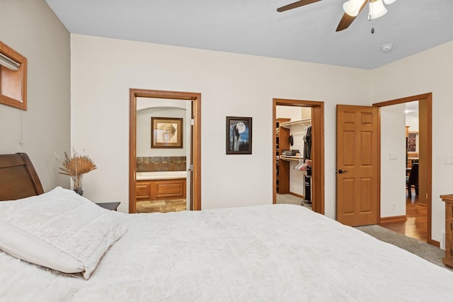 bedroom featuring ensuite bath, ceiling fan, a spacious closet, carpet floors, and a closet