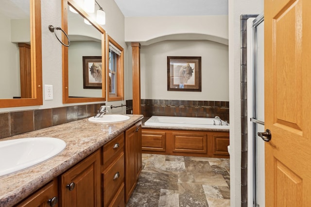 bathroom featuring vanity and independent shower and bath