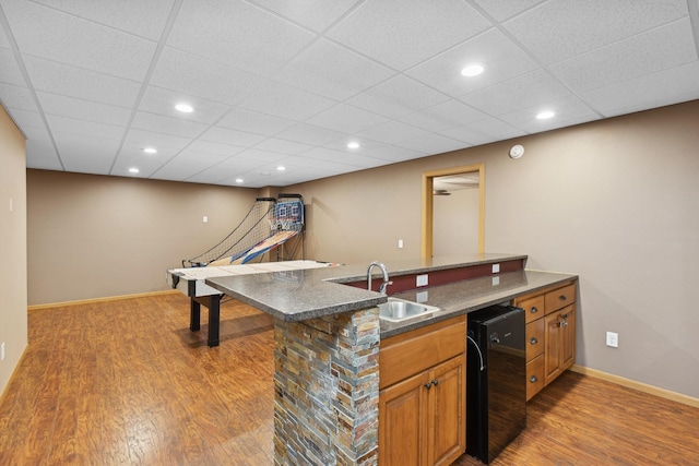 kitchen featuring kitchen peninsula, a paneled ceiling, hardwood / wood-style floors, and sink