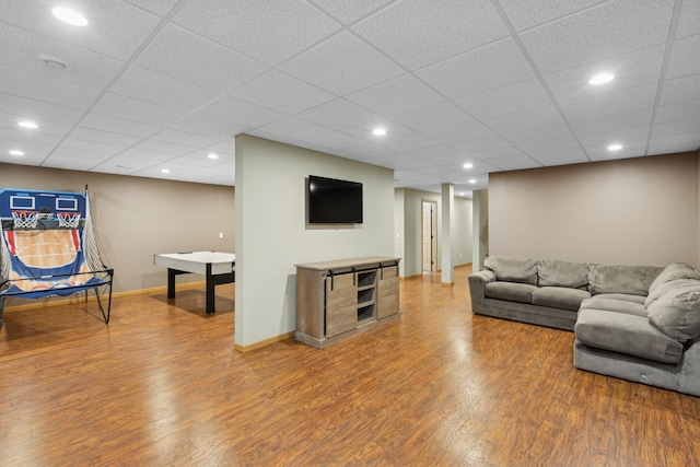 living room featuring hardwood / wood-style floors and a drop ceiling