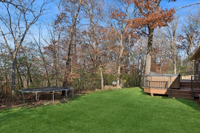 view of yard featuring a trampoline and a deck