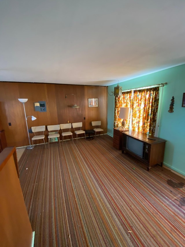 unfurnished living room featuring a notable chandelier and wood walls