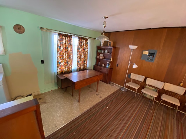 dining space featuring wood walls