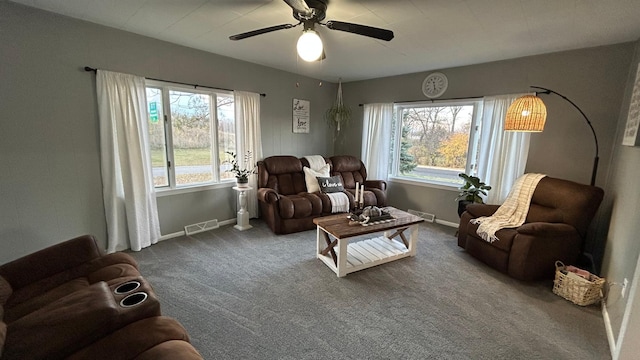 living area with ceiling fan, a wealth of natural light, and carpet floors