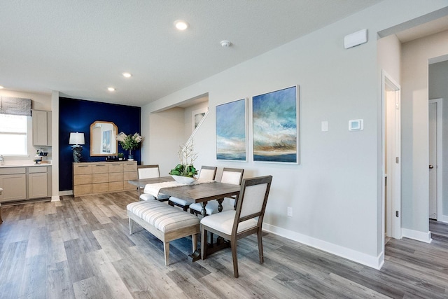 dining area with light hardwood / wood-style flooring and a textured ceiling