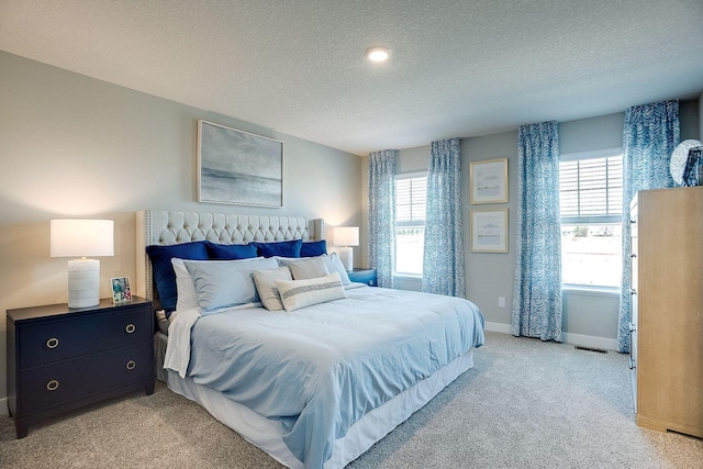 carpeted bedroom with multiple windows and a textured ceiling