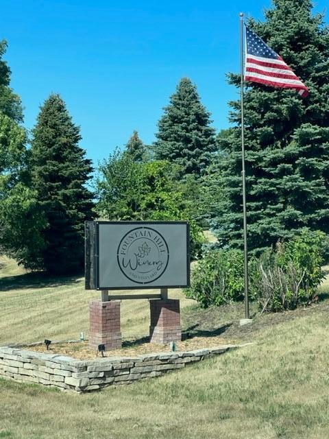 community / neighborhood sign featuring a yard