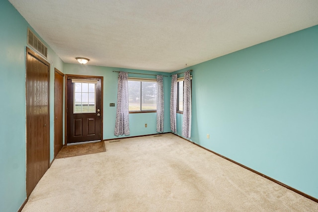 interior space with light colored carpet and a textured ceiling