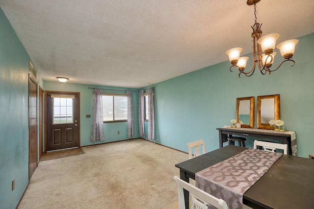 carpeted dining room with a chandelier and a textured ceiling