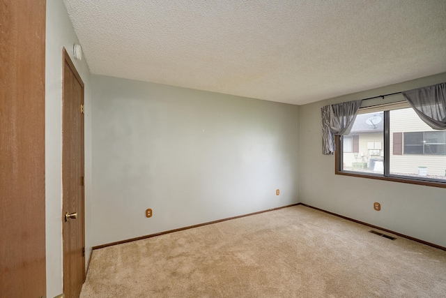 empty room featuring light carpet and a textured ceiling