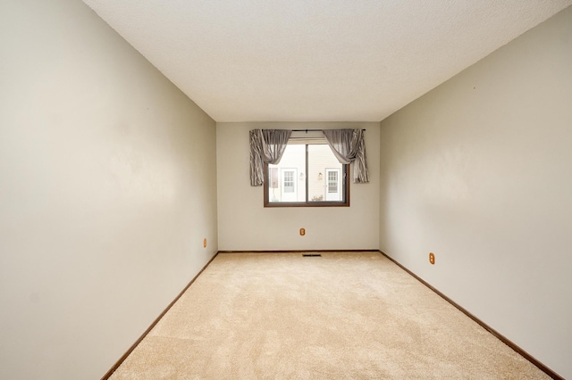 carpeted spare room with a textured ceiling