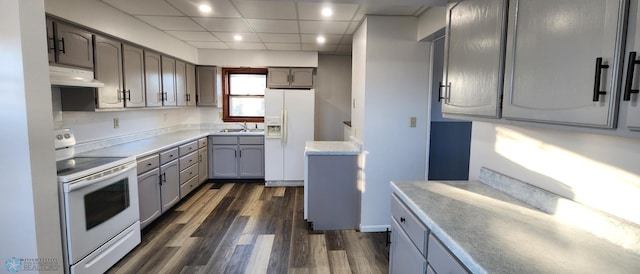 kitchen featuring extractor fan, dark wood-type flooring, sink, a paneled ceiling, and white appliances