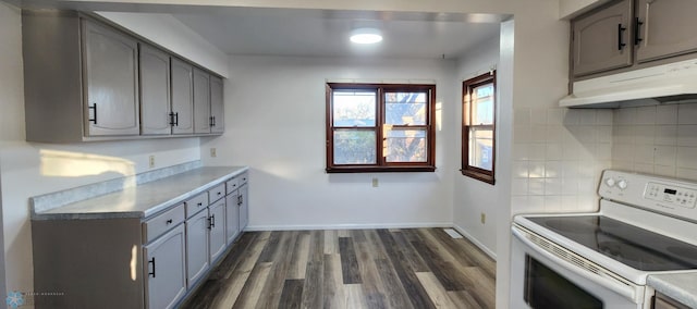 kitchen with tasteful backsplash, dark hardwood / wood-style flooring, white range with electric cooktop, and gray cabinets