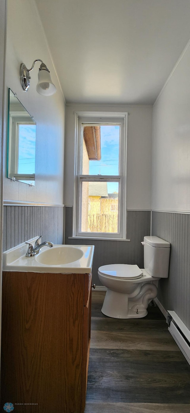 bathroom with vanity, toilet, a baseboard radiator, and hardwood / wood-style floors