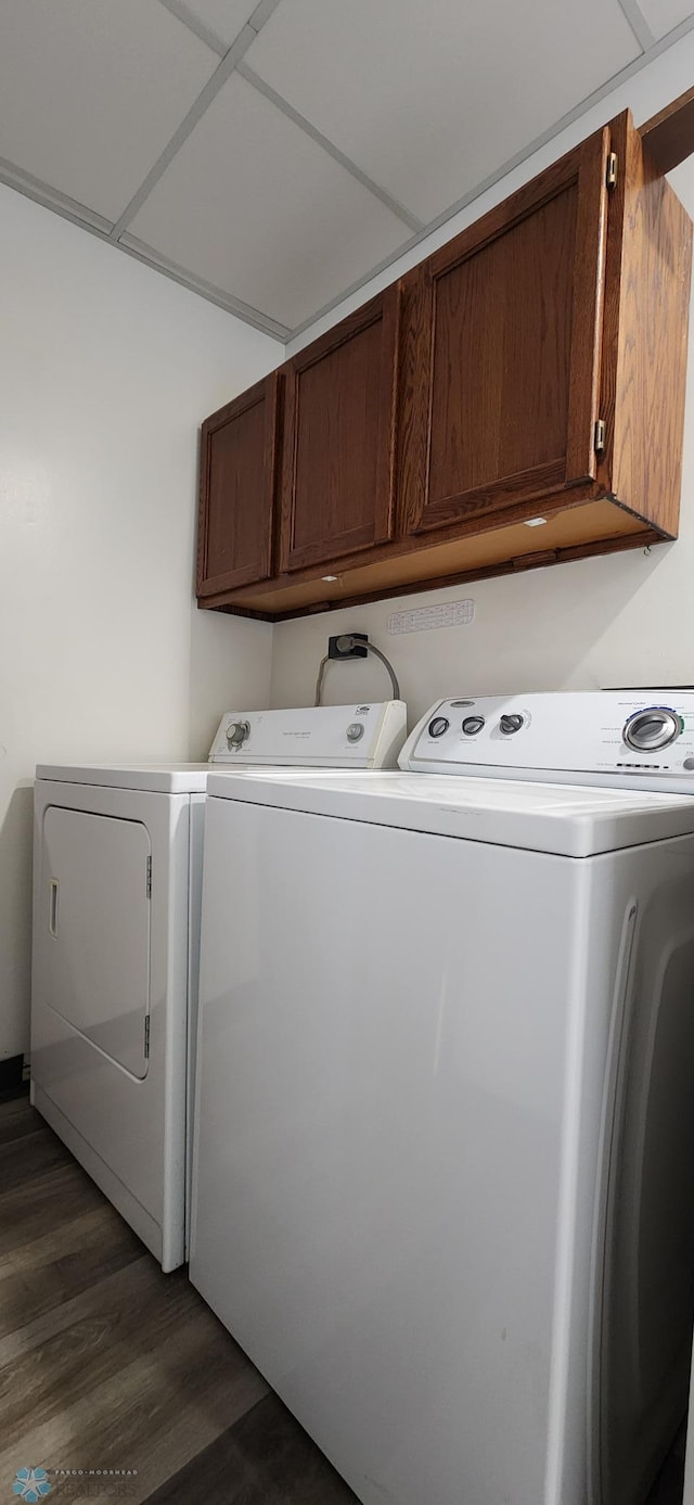 laundry area with independent washer and dryer, cabinets, and dark hardwood / wood-style flooring