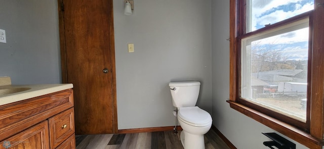 bathroom featuring toilet, hardwood / wood-style flooring, vanity, and plenty of natural light