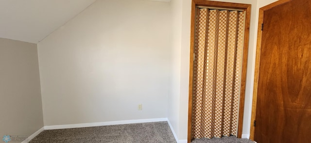 unfurnished bedroom featuring lofted ceiling and carpet floors