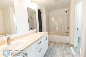 8447 61st St S, Horace, ND 58047 - full bathroom with double vanity, bathing tub / shower combination, wood finished floors, and toilet