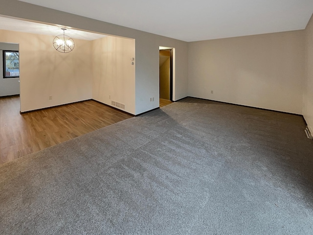 empty room featuring dark hardwood / wood-style floors and a chandelier