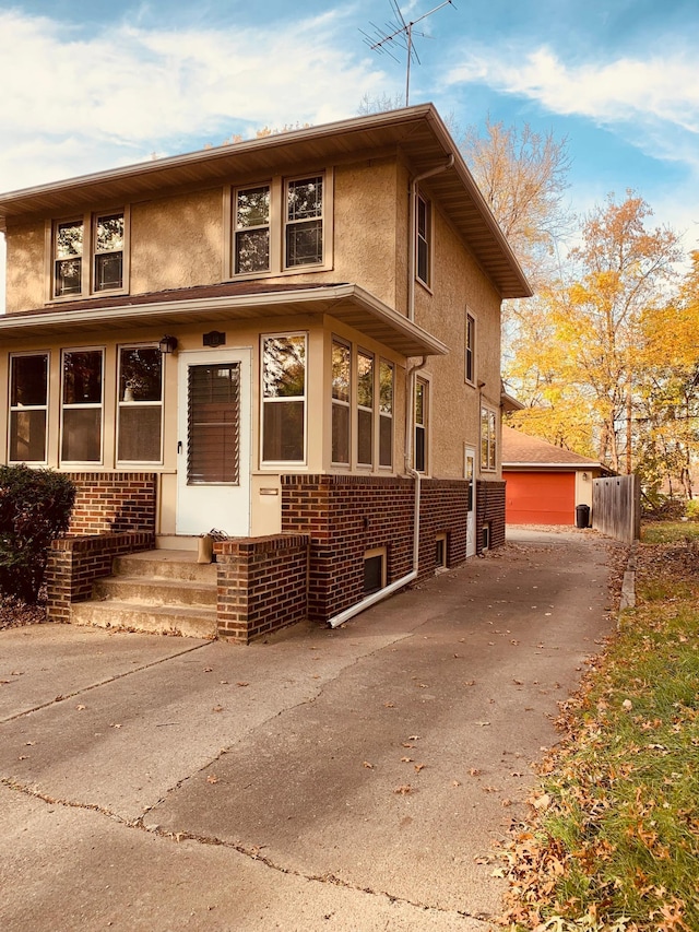 view of front of home with a garage and an outbuilding