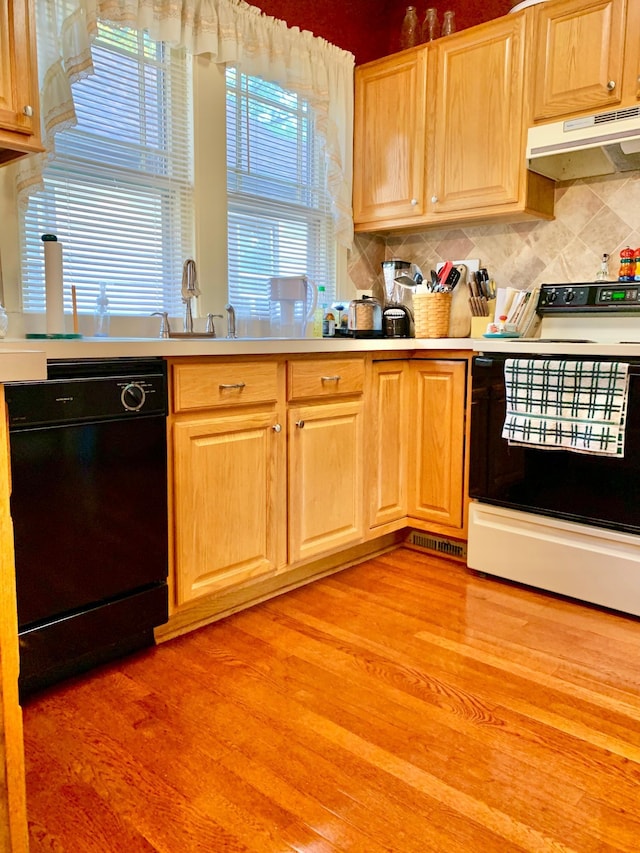 kitchen featuring exhaust hood, dishwasher, electric range, and light wood-type flooring