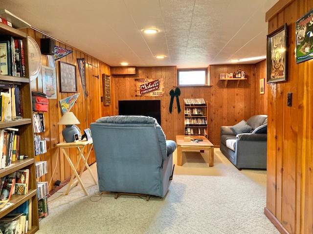 living area with light carpet and wood walls