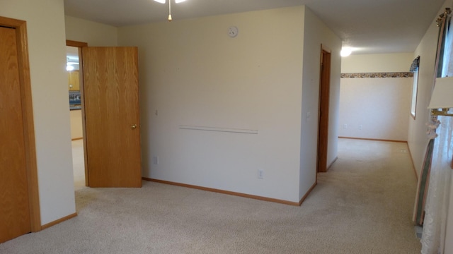 interior space featuring light carpet and ceiling fan