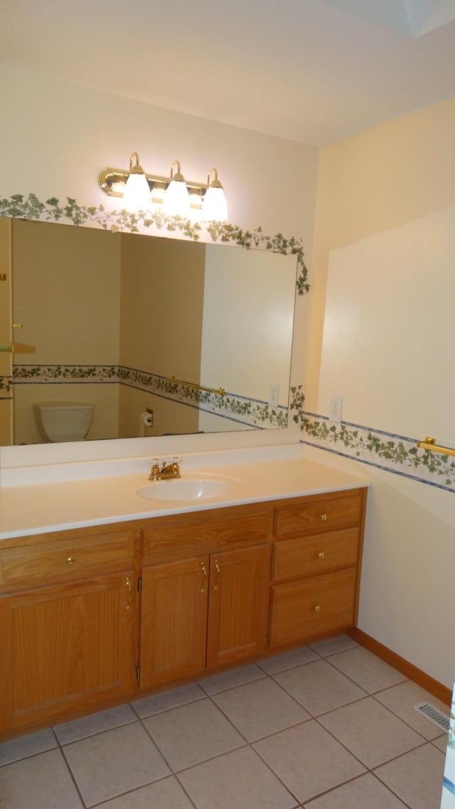 bathroom with tile patterned flooring, vanity, and toilet