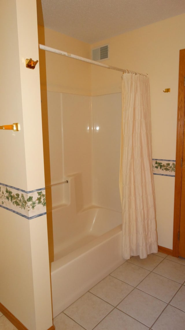 bathroom with shower / bath combination with curtain, tile patterned flooring, and a textured ceiling