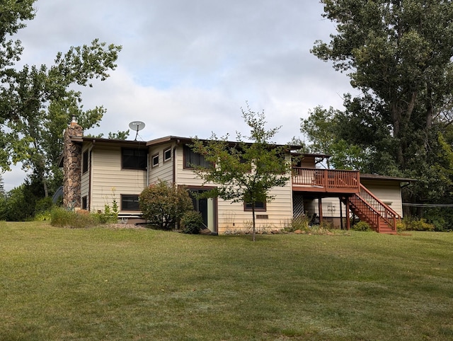 back of property featuring a wooden deck and a lawn