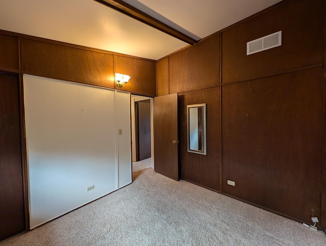 carpeted spare room featuring beam ceiling