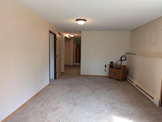 carpeted spare room featuring a textured ceiling and baseboard heating