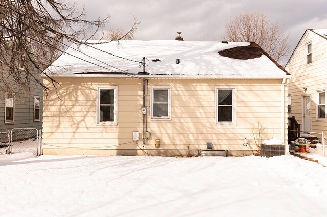 snow covered house with fence