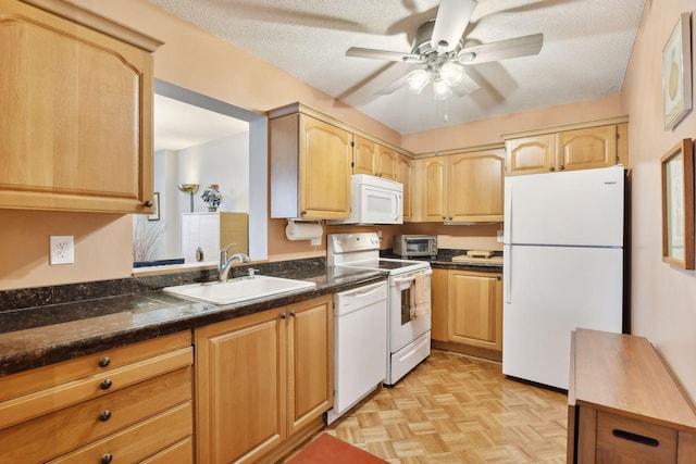 kitchen with light parquet floors, white appliances, sink, and a textured ceiling