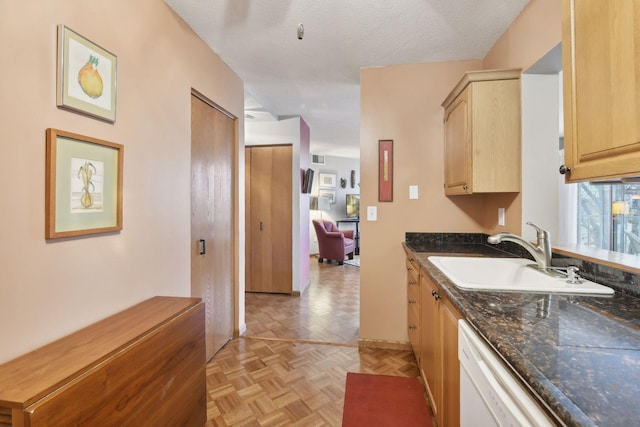 kitchen featuring dishwasher, a textured ceiling, sink, light brown cabinets, and light parquet flooring