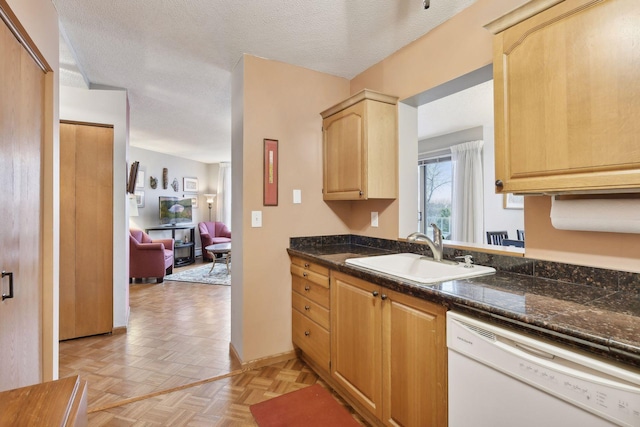 kitchen featuring light parquet floors, dishwasher, a textured ceiling, sink, and light brown cabinets