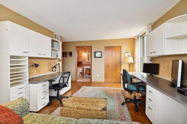 office area with dark wood-type flooring and a textured ceiling