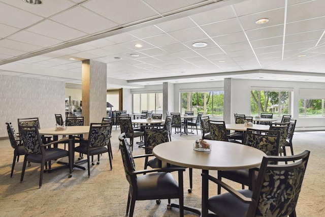 dining area featuring a paneled ceiling, carpet floors, and a baseboard radiator