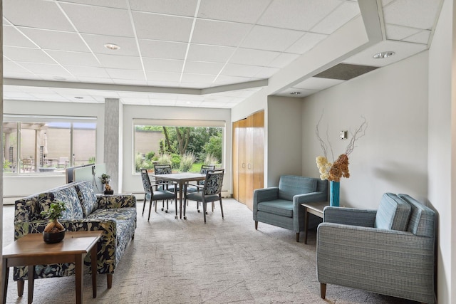 living room featuring carpet floors and a paneled ceiling