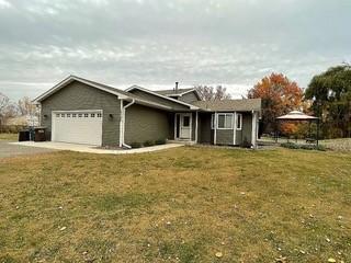 ranch-style home featuring a garage and a front yard