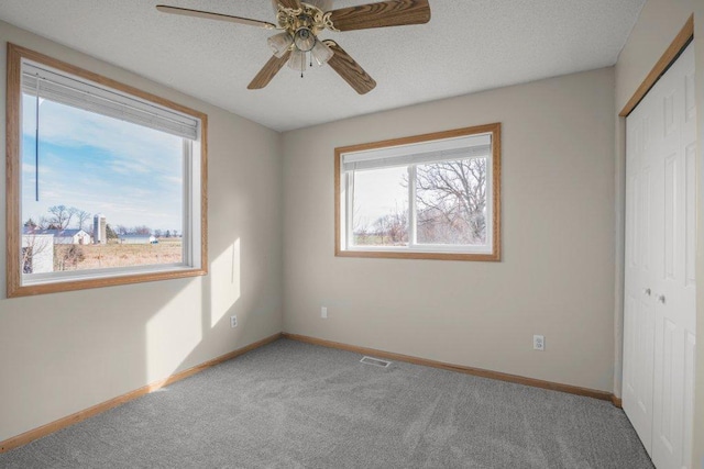 unfurnished bedroom featuring ceiling fan, a closet, and light colored carpet