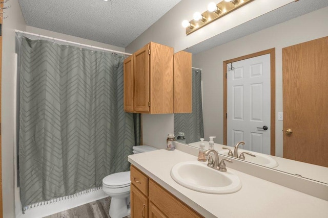 bathroom with vanity, hardwood / wood-style floors, a textured ceiling, and toilet