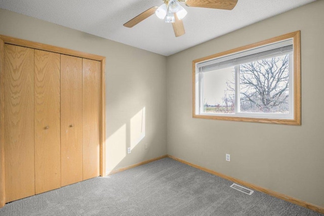 unfurnished bedroom with ceiling fan, light colored carpet, and a closet