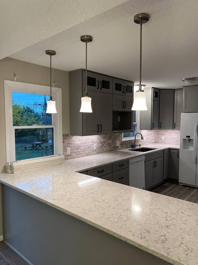 kitchen featuring gray cabinets, sink, white appliances, and decorative light fixtures