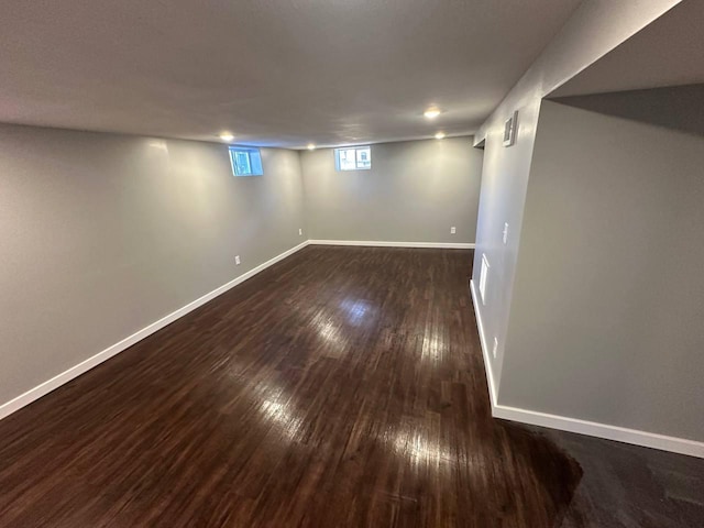 basement featuring dark wood finished floors and baseboards